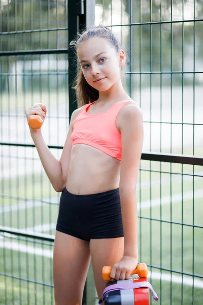 İnce vücut inşa genç güzel kız, spor formunda giyinmiş açık spor meşgul