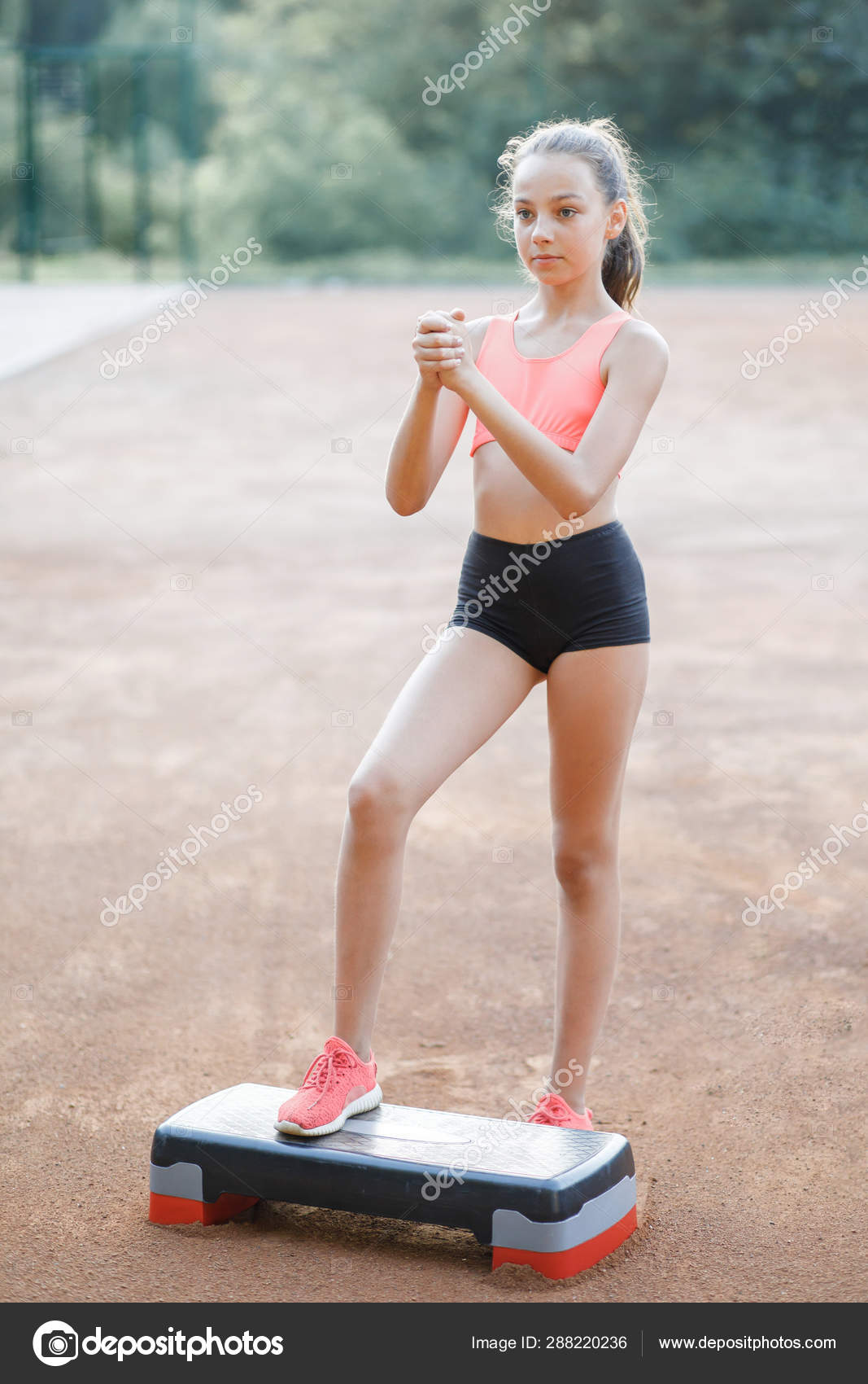 A cute pretty teenage girl performs various outdoor exercises Stock Photo nazariykarkhut 288220236