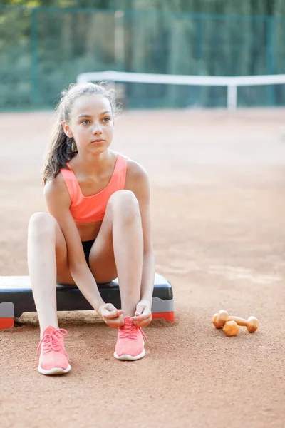 귀여운, 예쁜 십대 소녀는 단계 플랫폼에 앉아 야외에서 그녀의 운동 후 휴식 — 스톡 사진