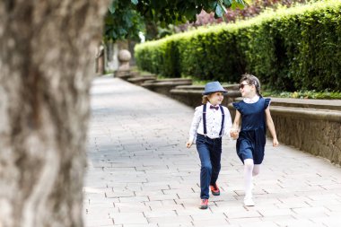 Sevimli sarışın adam ve sevimli kız, okul yılı eğlenceli zaman açık havada. Okul üniforması giymiş çocuklar parkta oyun oynar