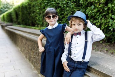 Sevimli sarışın adam ve sevimli kız, okul yılı eğlenceli zaman açık havada. Okul üniforması giymiş çocuklar parkta oyun oynar