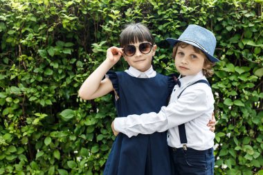 Sevimli sarışın adam ve sevimli kız, okul yılı eğlenceli zaman açık havada. Okul üniforması giymiş çocuklar parkta oyun oynar