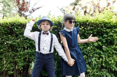 Sevimli sarışın adam ve sevimli kız, okul yılı eğlenceli zaman açık havada. Okul üniforması giymiş çocuklar parkta oyun oynar