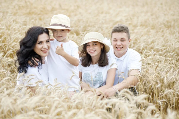 Happy family - brothers, sister and mom have fun on the wheat field. Summer vacation time — Stock Photo, Image