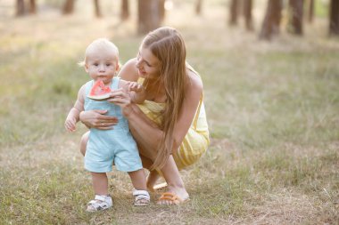 Sevimli genç kadın - anne aktif doğada onun küçük oğlu ile zaman harcıyor. Çocuk 10 aylık. Güzel bir aile yaz günü var