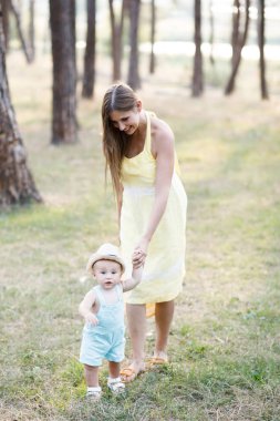 Sevimli genç kadın - anne aktif doğada onun küçük oğlu ile zaman harcıyor. Çocuk 10 aylık. Güzel bir aile yaz günü var