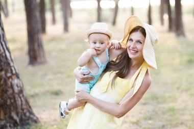 Sevimli genç kadın - anne aktif doğada onun küçük oğlu ile zaman harcıyor. Çocuk 10 aylık. Güzel bir aile yaz günü var