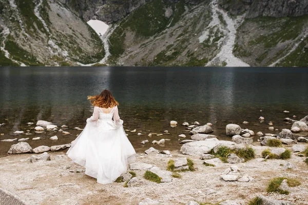 Mooie jonge vrouw die tijd doorbrengt in de bergen bij het meer. De bruid komt eraan. Huwelijksreis — Stockfoto