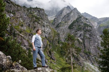 Genç, güçlü bir adam gölün yanındaki dağlarda duruyor. Büyülü manzara. Damat geliyor. Balayı
