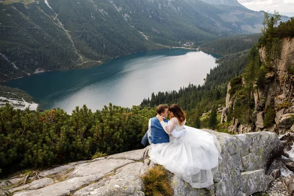 Linda pareja amorosa joven pasar tiempo en las montañas cerca del lago. Un par de recién casados caminan solos. Luna de miel — Foto de Stock