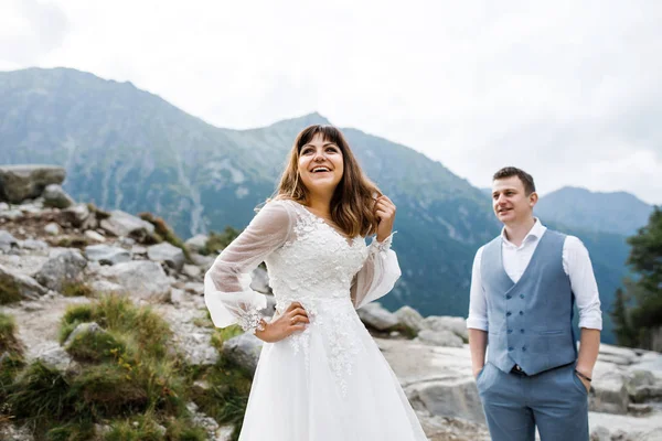 Nettes junges Liebespaar, das Zeit in den Bergen am See verbringt. Ein paar Frischvermählte gehen allein hinauf. Flitterwochen — Stockfoto