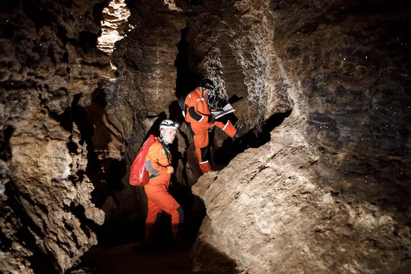 Güçlü fiziği olan iki adam mağarayı keşfeder. Mağaradan geçmek için özel giyinmiş adamlar durup haritaya baktılar.