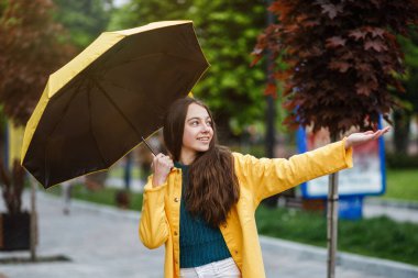 Genç, güzel bir genç kız yağmurlu havada şehirde dolaşır. Kız renkli kıyafetler ve lastik çizmeler giyiyor.