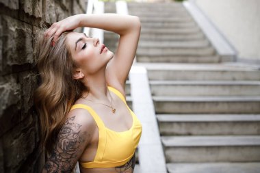Merdivenlerde oturan bir kadının sokak modası yaz portresi