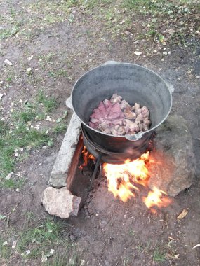 Açık havada bir kast üzerinde et ile büyük bir kazan