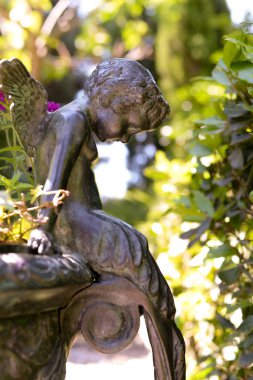 kafasını sarkan bronz melek oturur