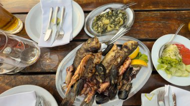 Bir tabak deniz ürünü ve servis masası.