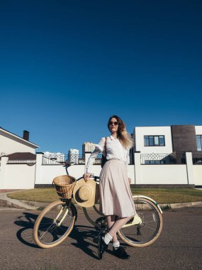 Güzel kız şapkalı ve kruvazör Bisiklet banliyösünde tarafından elbise.