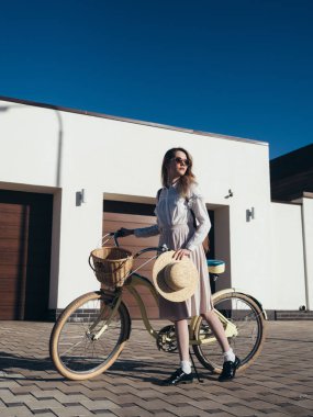 Güzel kız şapkalı ve kruvazör Bisiklet banliyösünde tarafından elbise.