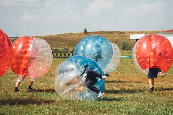 İnsanlar bumperball zorbsoccer açık oynarlar. Yaz saati.