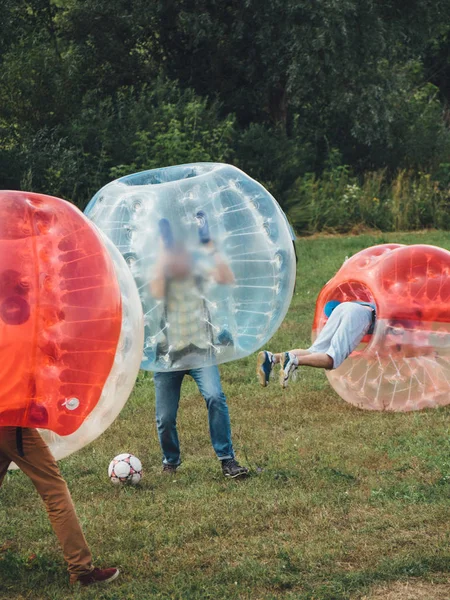 İnsanlar bumperball zorbsoccer açık oynarlar. Yaz saati.