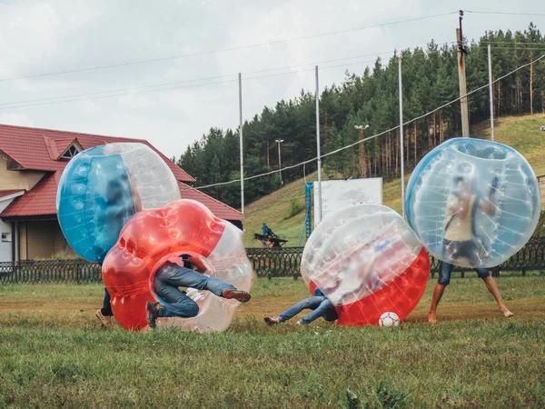 İnsanlar bumperball zorbsoccer açık oynarlar. Yaz saati.