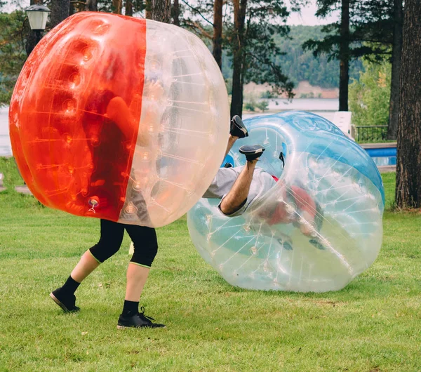 İnsanlar bumperball zorbsoccer açık oynarlar. Yaz saati.