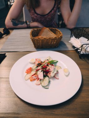 Kafede masada sebze salatası ile genç kız.