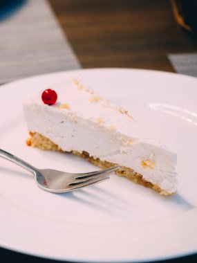 Berry Cafe plaka ile beyaz chessecake parçası.