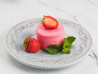 Çilek ve nane ile yuvarlak pembe mini cheesecake.