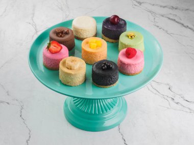 Yuvarlak mini cheesecakes meyve ve çilek stand ile.