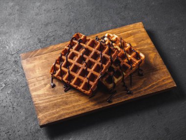 Ahşap tahta üzerinde çikolata ile Belçika Waffle.