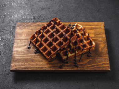 Ahşap tahta üzerinde çikolata ile Belçika Waffle.