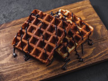 Ahşap tahta üzerinde çikolata ile Belçika Waffle.