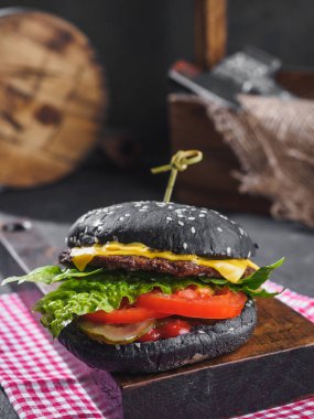 Ahşap tahta üzerinde siyah sığır eti burger.
