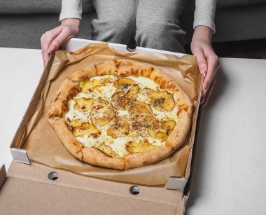 Teslimat kutusunda armut ve dor mavi peynirile Pizza. Kadın elleri