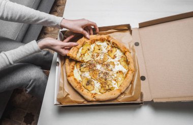 Teslimat kutusunda armut ve dor mavi peynirile Pizza. Kadın elleri