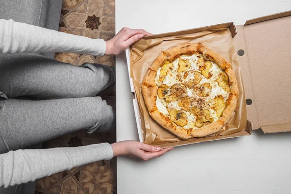 Pizza con pera y queso azul olor en caja de entrega. Manos femeninas — Foto de Stock