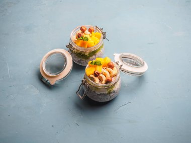 Hindistan cevizi sütü, mango ve fındık ile kavanozda Chia tohum puding