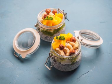 Hindistan cevizi sütü, mango ve fındık ile kavanozda Chia tohum puding