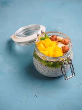 Hindistan cevizi sütü, mango ve fındık ile kavanozda Chia tohum puding