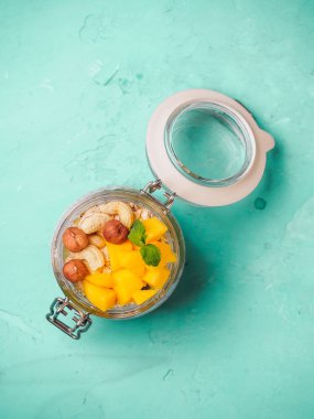Hindistan cevizi sütü, mango ve fındık ile kavanozda Chia tohum puding