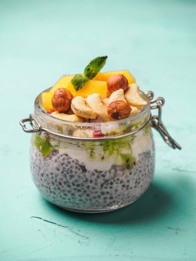 Hindistan cevizi sütü, mango ve fındık ile kavanozda Chia tohum puding