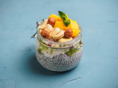 Hindistan cevizi sütü, mango ve fındık ile kavanozda Chia tohum puding