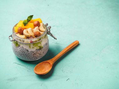 Hindistan cevizi sütü, mango ve fındık ile kavanozda Chia tohum puding