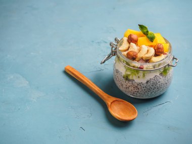 Hindistan cevizi sütü, mango ve fındık ile kavanozda Chia tohum puding