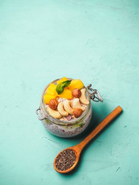 Hindistan cevizi sütü, mango ve fındık ile kavanozda Chia tohum puding