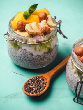 Hindistan cevizi sütü, mango ve fındık ile kavanozda Chia tohum puding