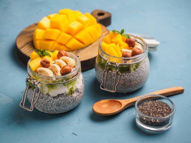 Hindistan cevizi sütü, mango ve fındık ile kavanozda Chia tohum puding