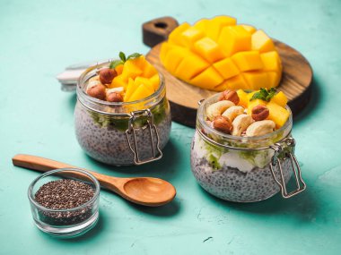 Hindistan cevizi sütü, mango ve fındık ile kavanozda Chia tohum puding